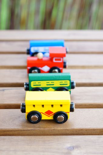 A vertical closeup shot of colorful toy cars on a wooden surface