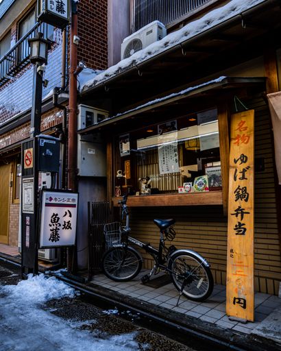Numerous signs displayed on building facade with bicycle parked in front