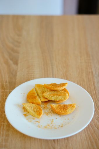 A vertical closeup shot of cookie pieces on a white plate on a wooden surface