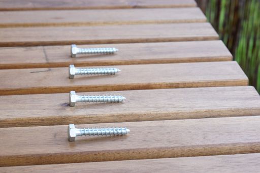 A high angle closeup shot of screws on a wooden table