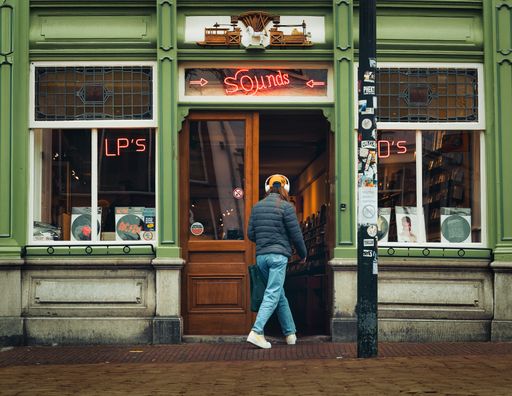 Customer wearing headphones enters Delft music store
