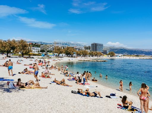 Beach full of people on a hot sunny summer day in Znjan or Trstenik in Split, Croatia.