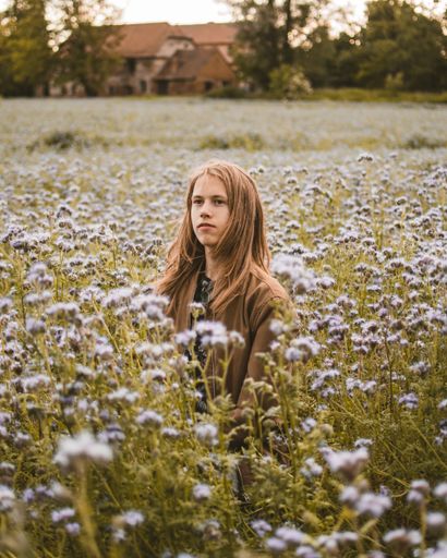 A young Caucasian male standing in a field on a sunny day