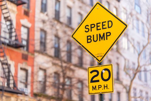 A Yellow Speed Bump Sign in the city