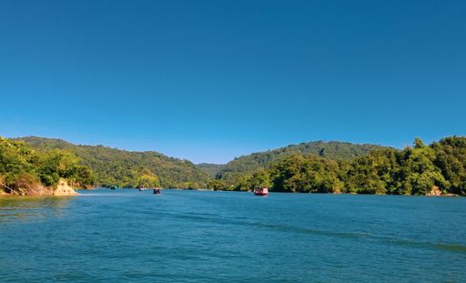 A sunny day in India with a clear blue sky above the Vazhani Dam in Viruppakka
