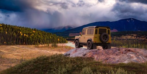 Land Rover Defender parked on a Rocky Peak with River in Green Valley with Mountains in Background. 3d Rendering.