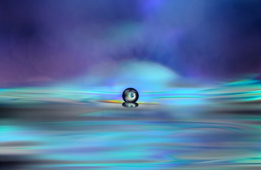 A selective focus of a glass ball against a colorful blurry background