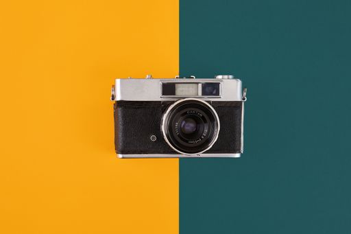 A camera against a yellow and green background