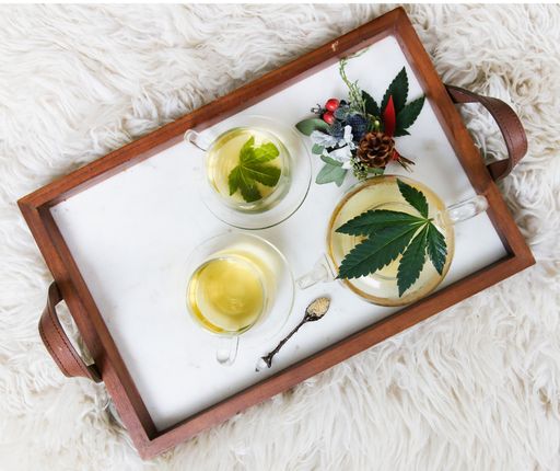 An overhead shot of a healthy CBD Infused Chamomile Based Tea on a wooden flat tray