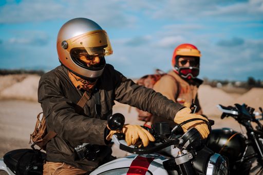 Two motorcyclists in desert, riding near each other, donning protective gear