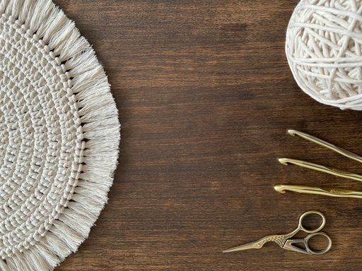 A top view of hooks and yarns with scissors for knitting on a wooden table