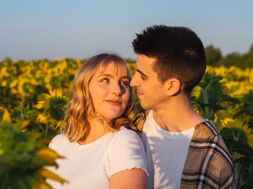 A portrait of a young cute couple in a sunflower field