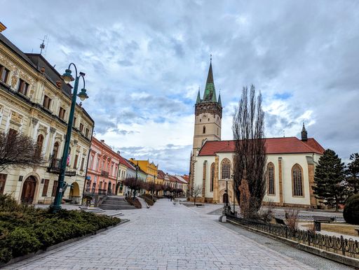 A cobblestone pathway flanked by historic buildings and towers in the Main Square in Presov, Eperjes Slovakia