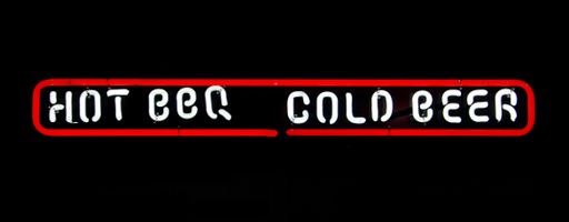 A glowing white sign saying "hot BBQ" and "cold beer" with a red outline on a pitch-black background