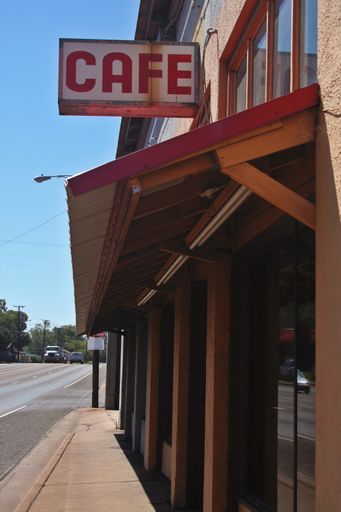 A vertical shot of a cafe sign downtown at the entrance