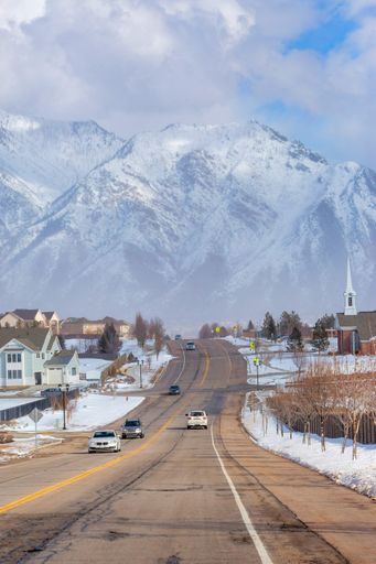 A road going toward a mountain through a town on a cloudy day
