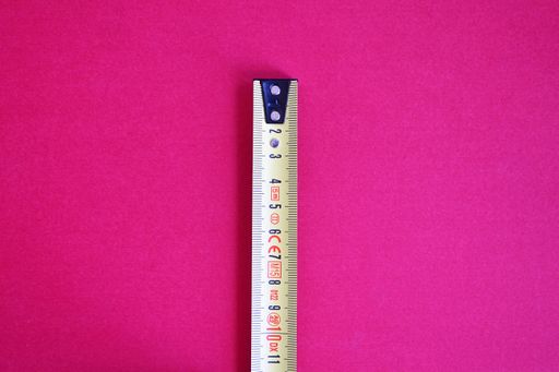 A tape measure isolated on a pink background