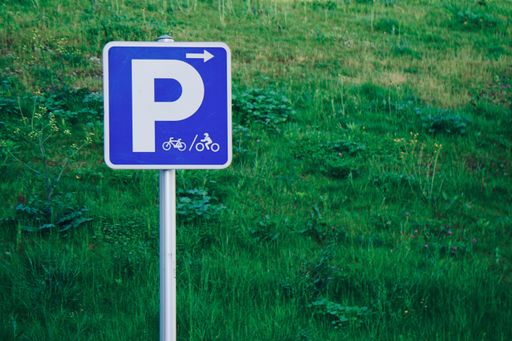 A parking sign for cyclists on the background of green grass