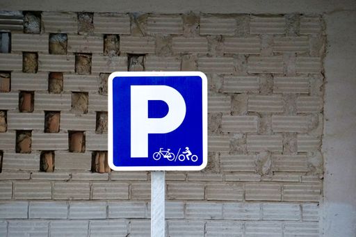 A parking sign for cyclists on the background of a building wall