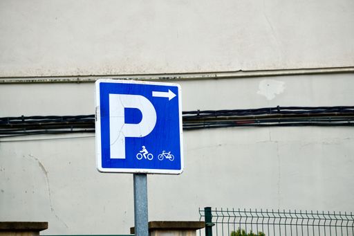 A parking sign for cyclists on the background of a wall