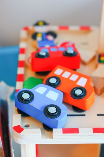 A vertical shot of colorful wooden car toys on a wooden surface