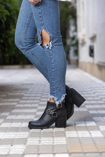 A vertical shot of a woman wearing boots outdoors