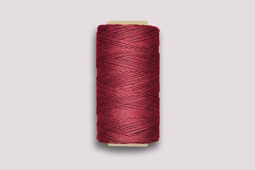 A high angle shot of maroon thread spools for sewing isolated on white background
