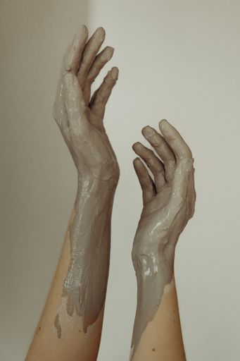 Two hand sculptures covered in white clay