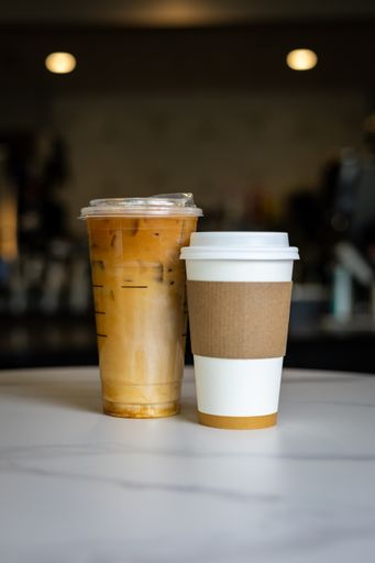 Two cups of coffee on white table, side by side
