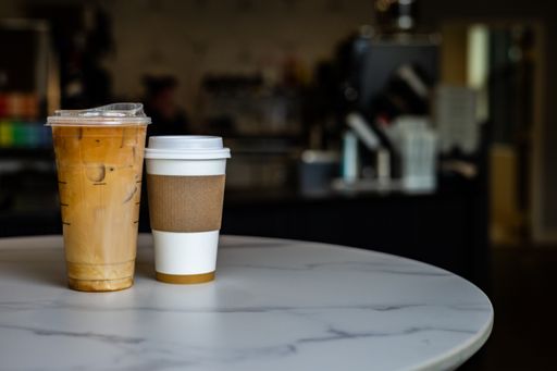 Two cups of coffee on white table, side by side