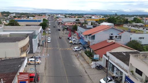 Cityscape with crowded streets and rooftops filled with people, cars, and buildings