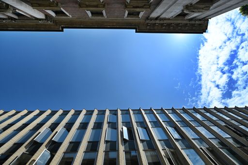 A low angle shot of two office buildings under the blue sky