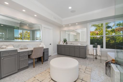 A modern bathroom with a bathtub, mirror, and sinks