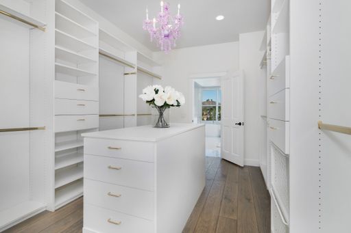 A white closet with open shelves and a large countertop
