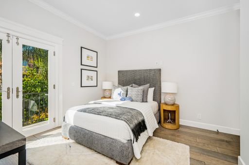 A tidy modern bedroom with doors opening to a patio