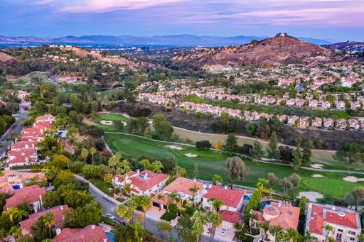 A picturesque golf course with homes in the foreground and rolling hills in the background