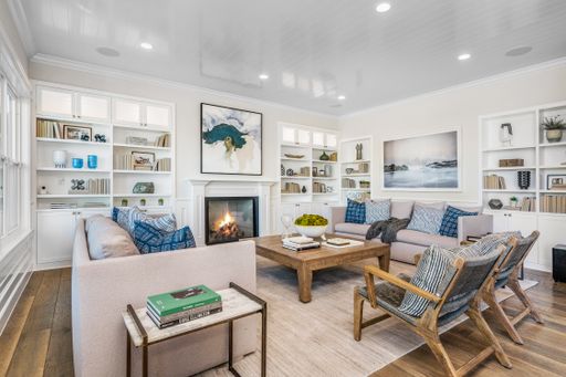 A cozy living room with sofa, armchairs, and a fireplace