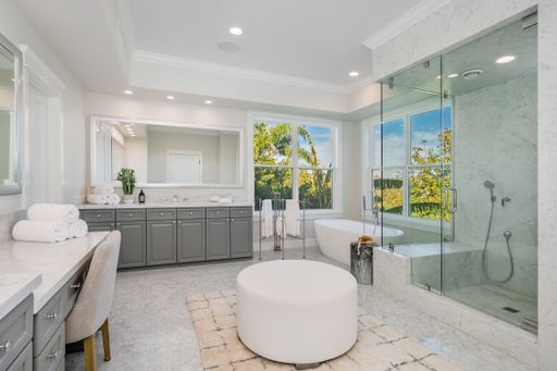 A modern bathroom featuring a walk-in shower, bathtub, and a window view