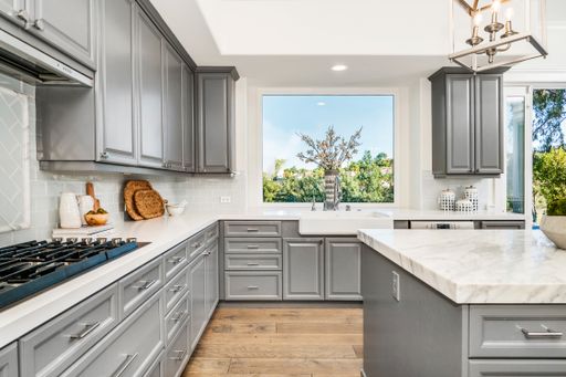 A modern marble kitchen with sleek gray cabinets