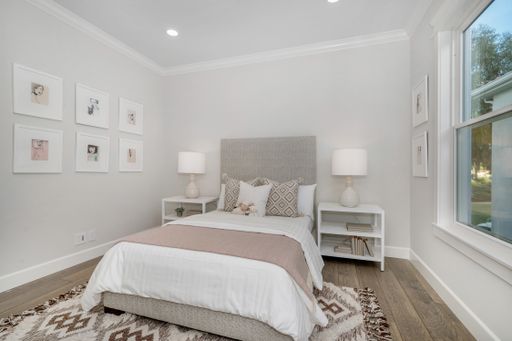A cozy bedroom with a bed with blankets, pillows, and rugs in a room