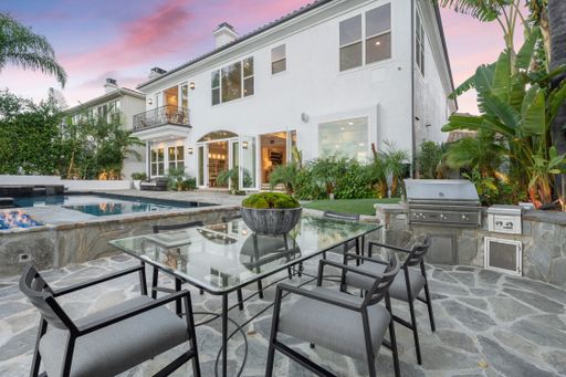 A modern house with a patio and a pool at sunset