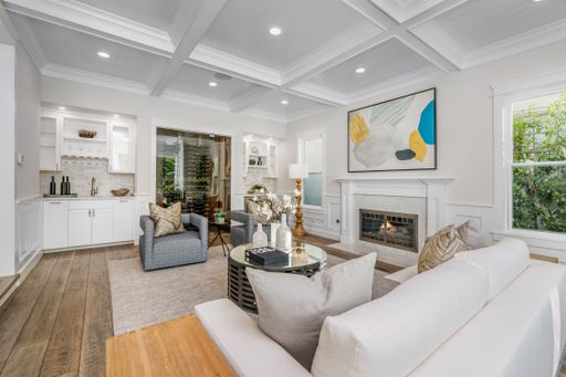 A modern living room with white walls, furniture, and a cozy fireplace