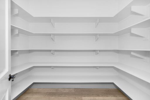 A spacious white pantry with empty shelves