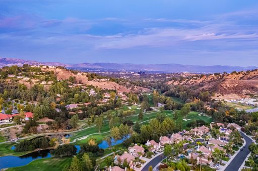 A sunrise view of a desert golf course surrounded by trees