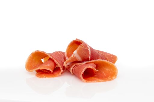 A closeup shot of ham slices or prosciutto isolated on a white background