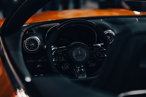 A closeup shot of the driving wheel of the Mercedes-Benz AMG SL with blur background