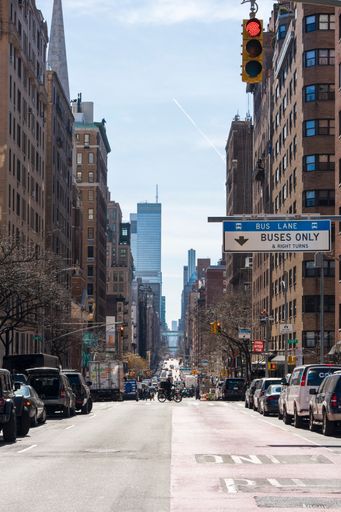 The grandeur of a New York City avenue, with towering skyscrapers flanking both sides, their facades gleaming under the city lights