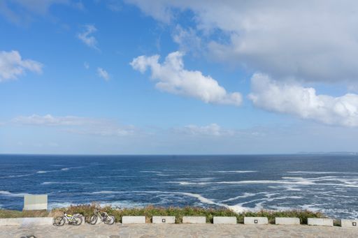 A panoramic viewpoint of A Coruna offers a view of the slightly choppy Atlantic Sea under a blue sky dotted with white clouds. Spain.