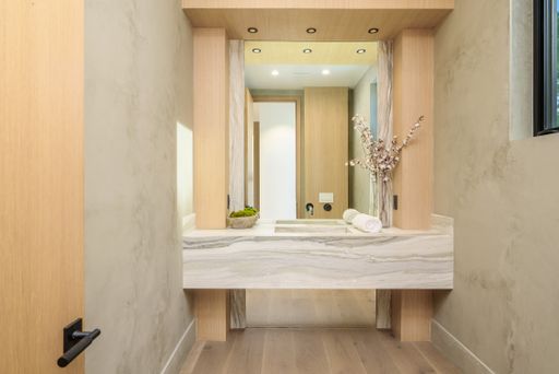 A modern bathroom with spacious vanity and oversized wall mirror.