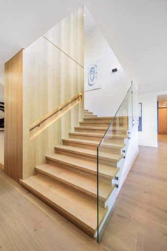 The wooden steps and floors in a room with white walls.